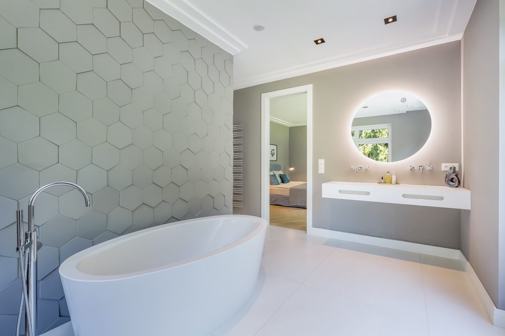 Architekturfotografen für Berlin - modernes Badezimmer in hellen Farben mit freistehender Badewanne und rundem Spiegel