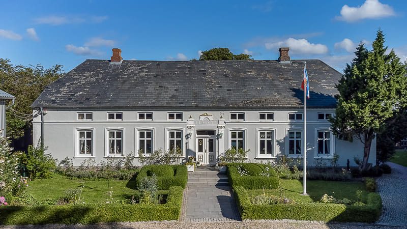 Immobilienfotograf für München - Landhaus, front Ansicht auf das Anwesen in weiss mit Cottage Garten
