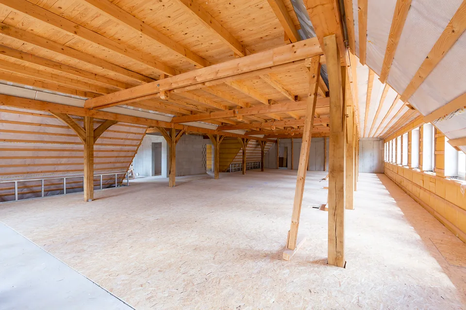 Rohbau: weites Dachgeschoss mit Holzständern und Dachschrägen