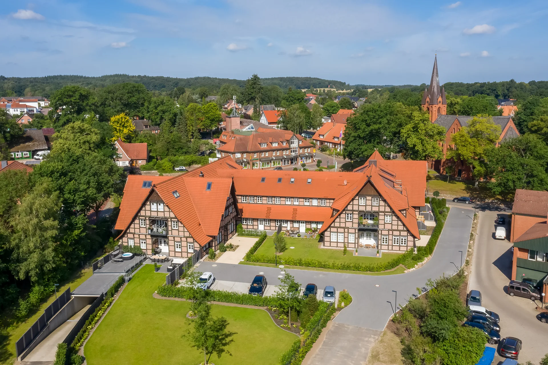 Luftaufnahme des fertigen Fachwerk-Ensembles mit Innenhof, Rasenfläche und Zufahrt