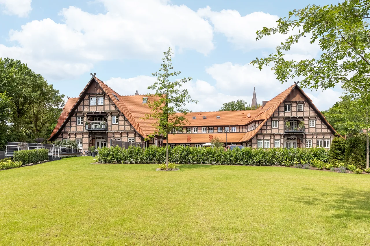 Fertig: Fachwerkhaus mit Seitenflügeln hinter einer Rasenfläche