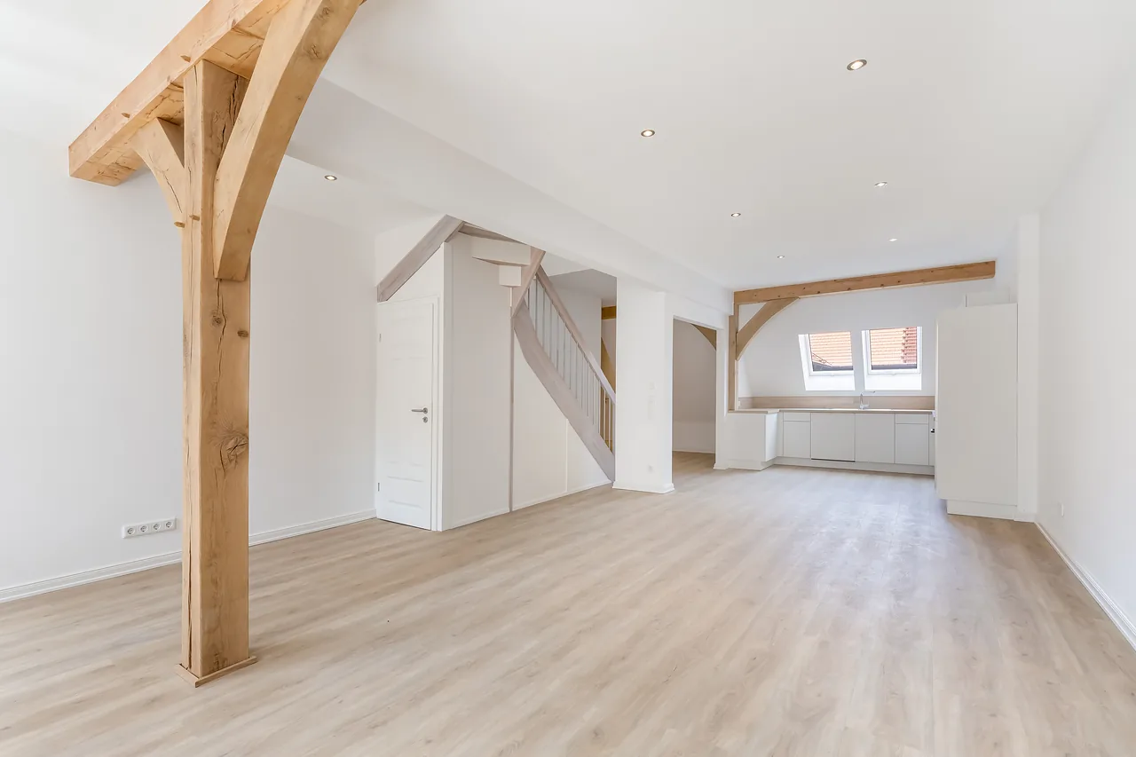 Fertig: Wohnung mit sichtbarer Holzstütze, Treppe und Küchenzeile
