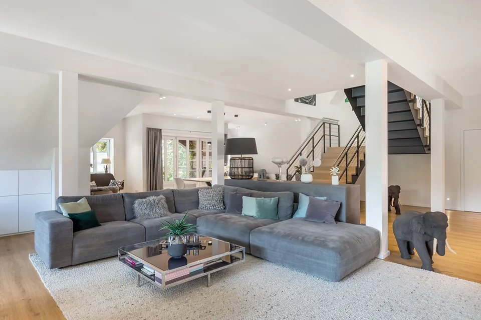 Fertige Wohnung: offener Wohnbereich mit Ecksofa, Kamin und Treppe