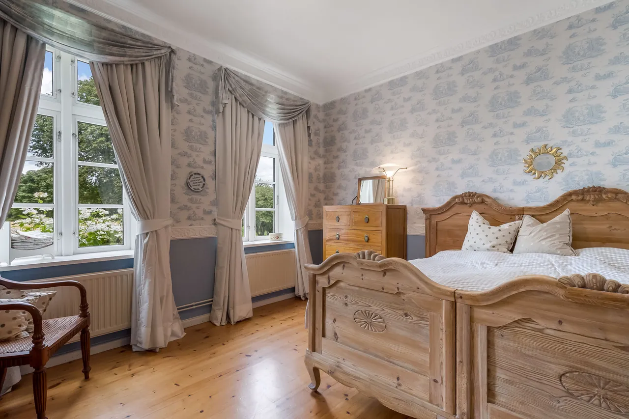 Nachher: Schlafzimmer mit Holzbetten, gemusterter Tapete und Fenstern mit Blick ins Grüne