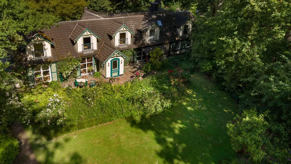 Luftaufnahme eines Landhauses mit Garten im Wald