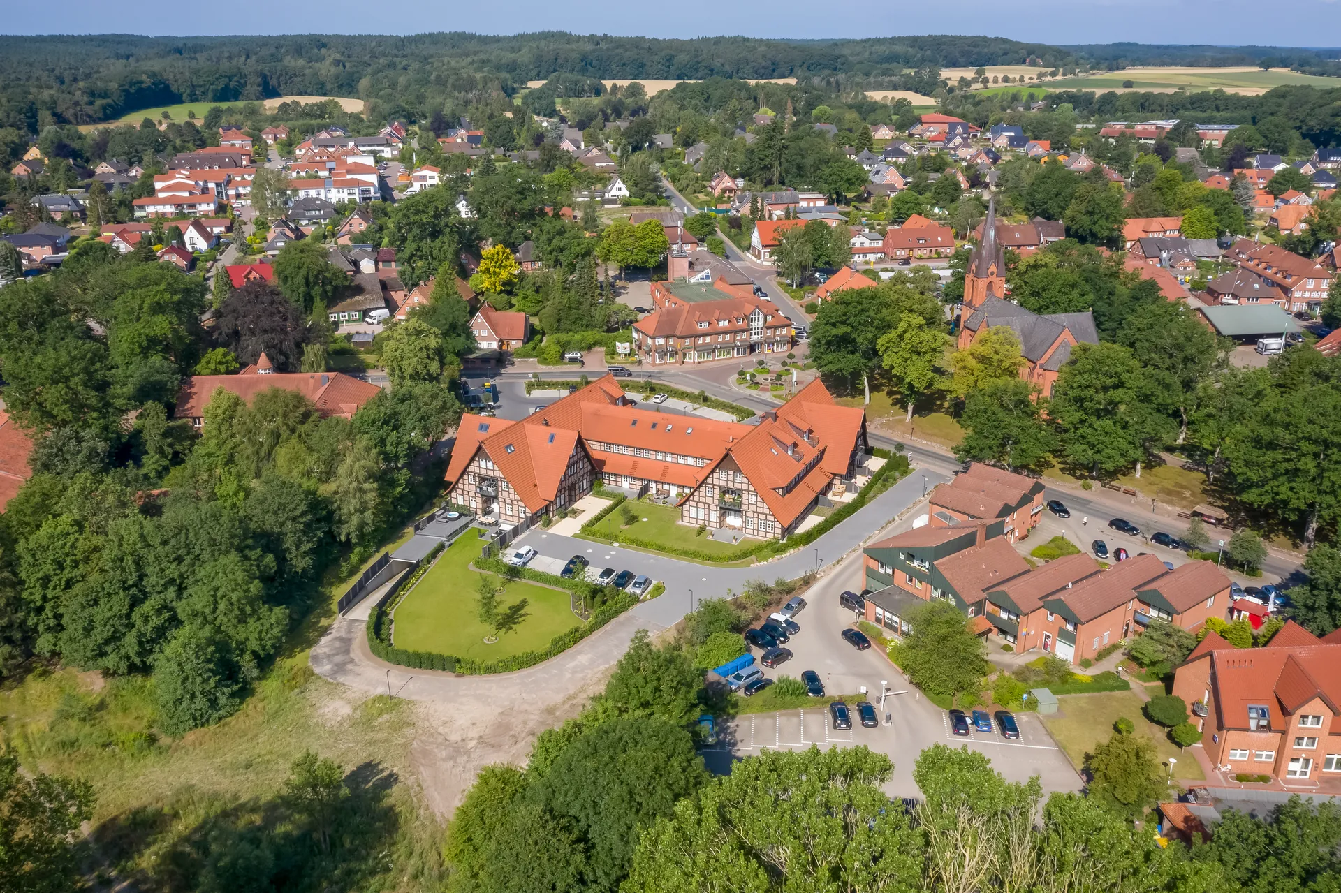 Luftbild über einen Ortskern mit Fachwerk- und Klinkerbauten, Kirche und Straßenzügen