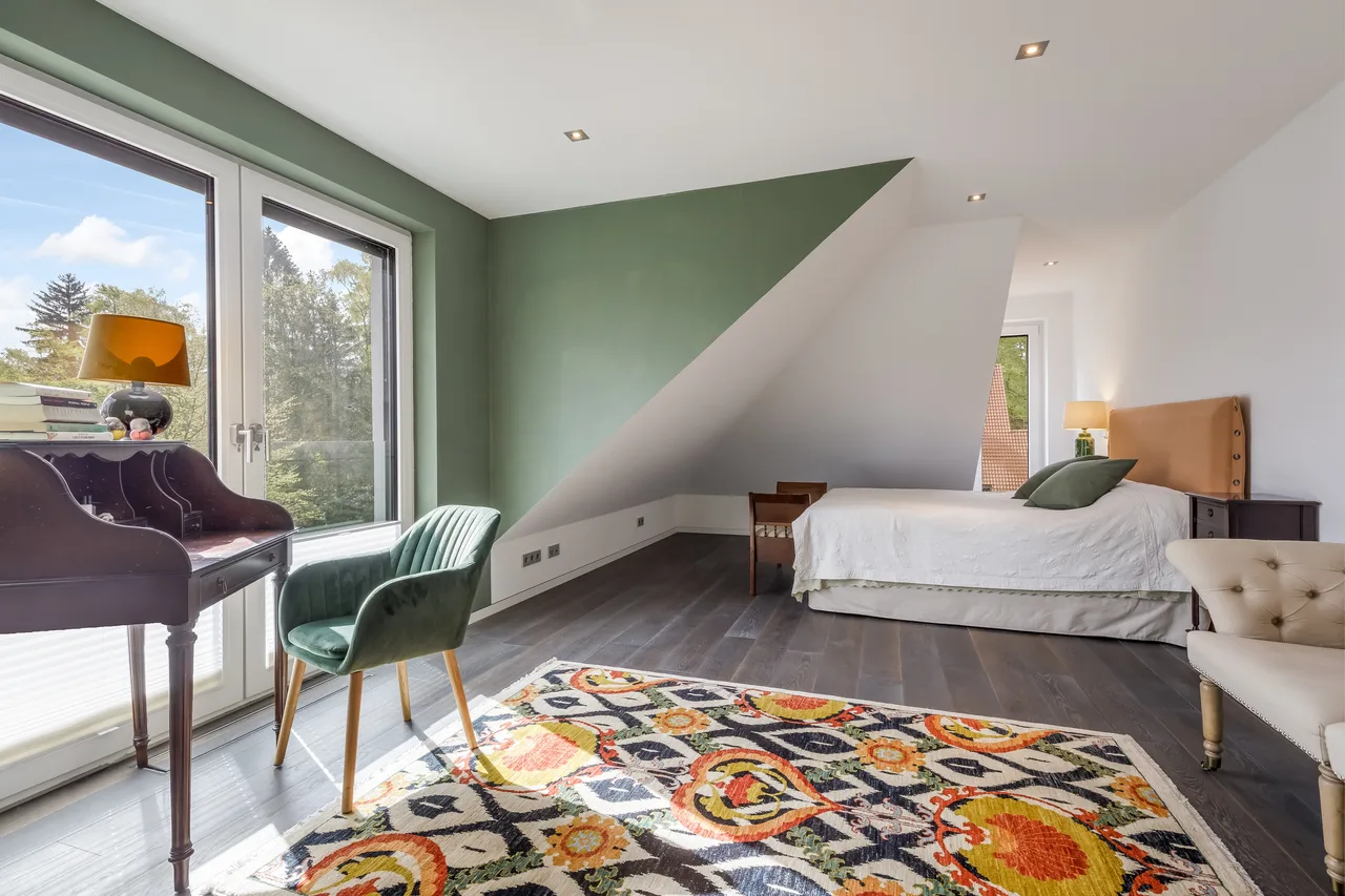 Dachzimmer mit Schreibtisch und grüner Akzentwand
