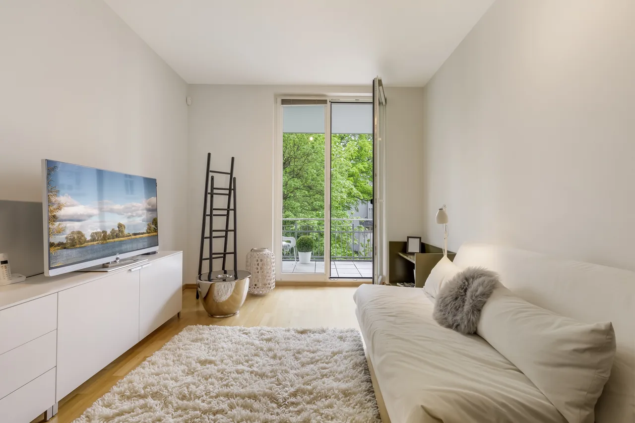 Helles Wohnzimmer mit Sofa und bodentiefem Fenster