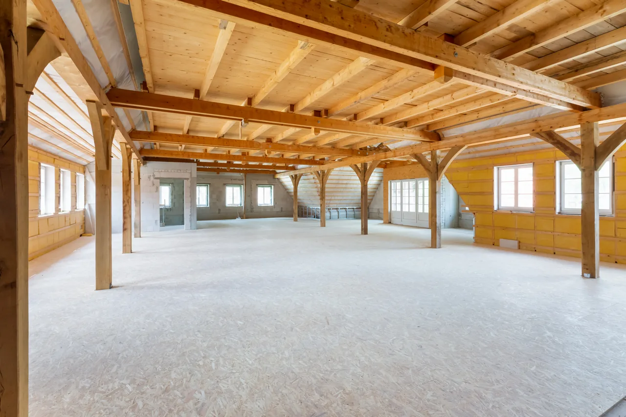Rohbau: Dachgeschoss mit offenem Holzfachwerk und unverkleidetem Boden