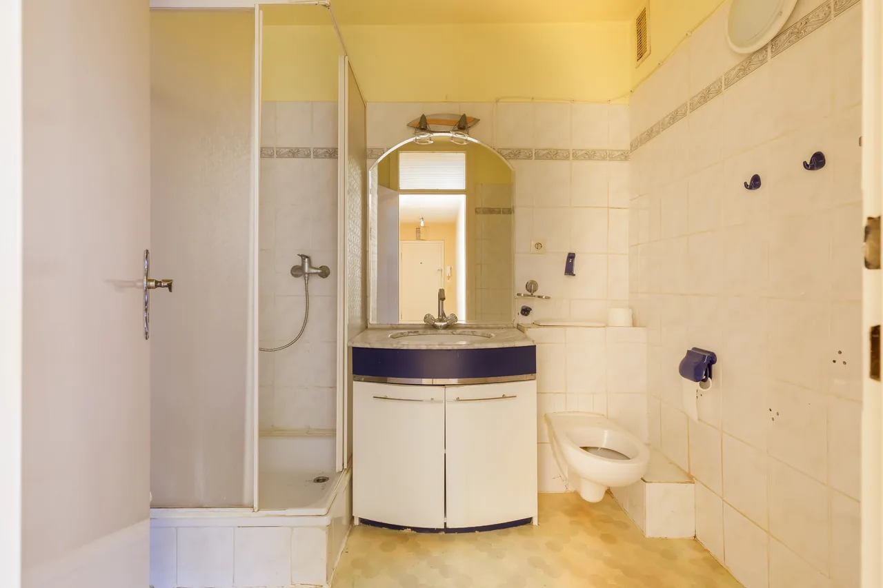 Vorher: Bad mit alten Fliesen, Duschkabine, Waschtisch mit Spiegelschrank und WC