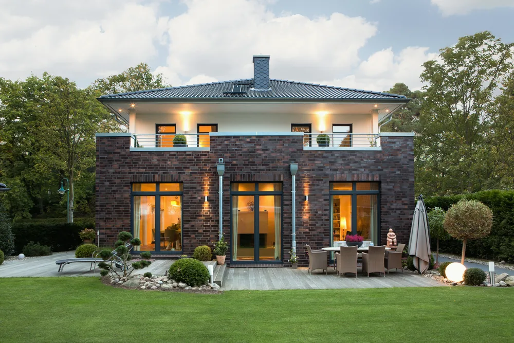 Villa mit Klinkerfassade und Terrasse in der Abenddämmerung
